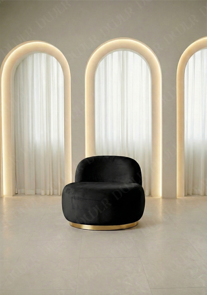 Black armchair in a room with arch-shaped light fixtures and white curtains.