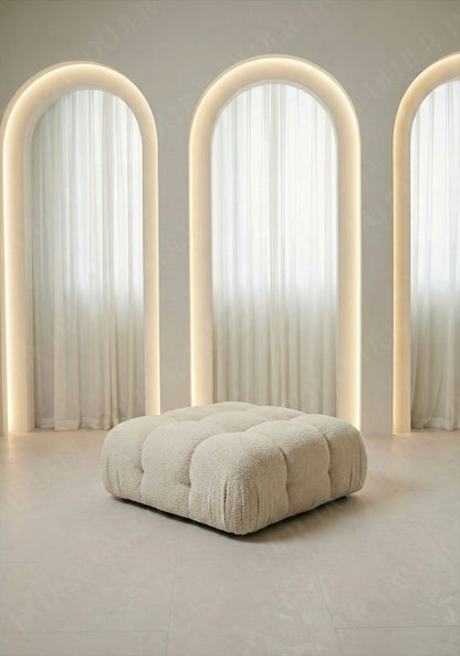 Cierra modular ottoman upholstered in off white boucle fabric designed to be used as footrest or seating extension