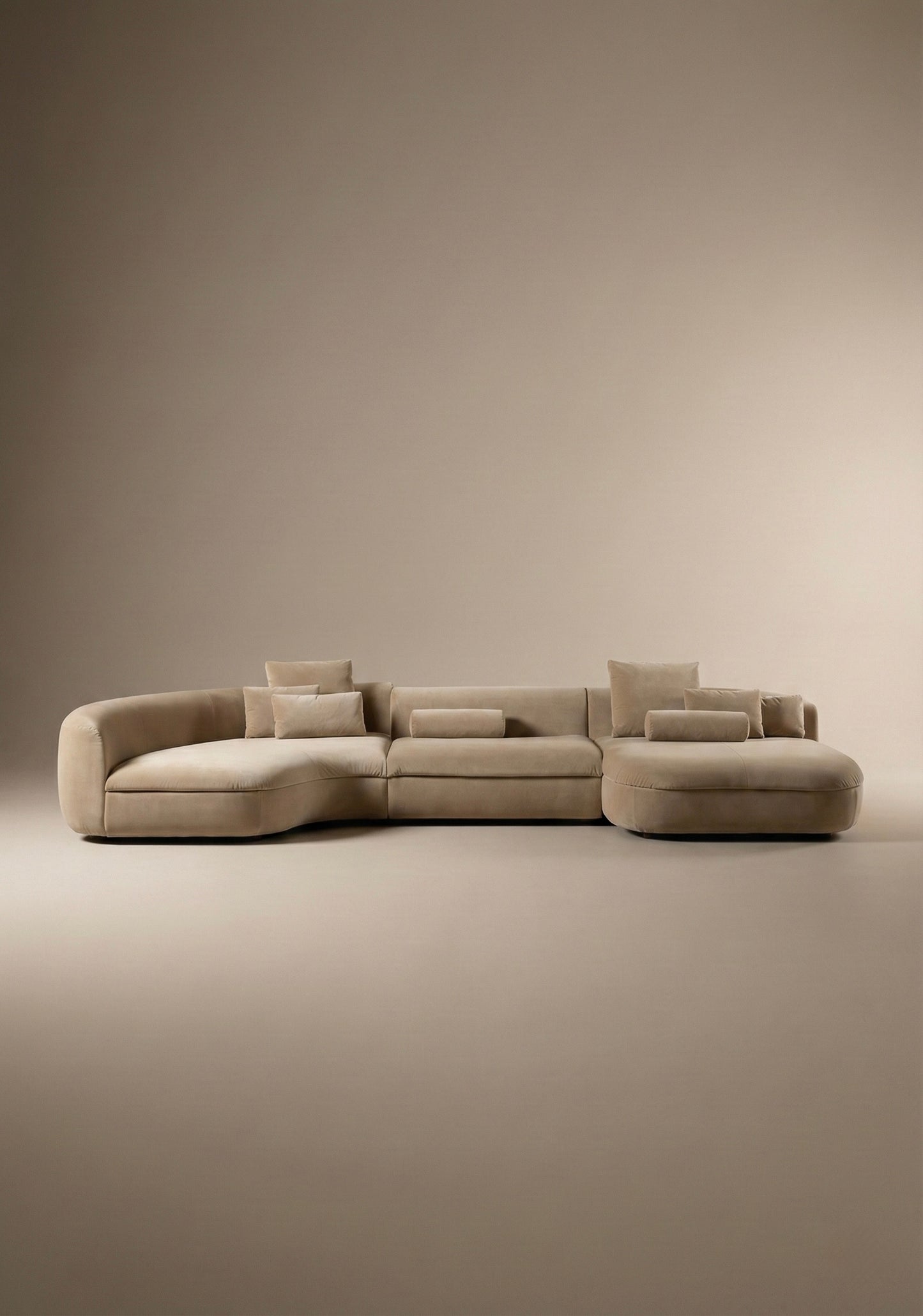 Large curved modular sofa in beige  velvet upholstery with sculptural form and modular layout