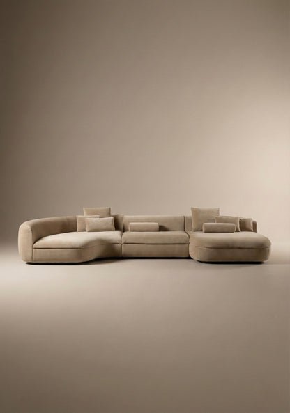 Large curved modular sofa in beige  velvet upholstery with sculptural form and modular layout