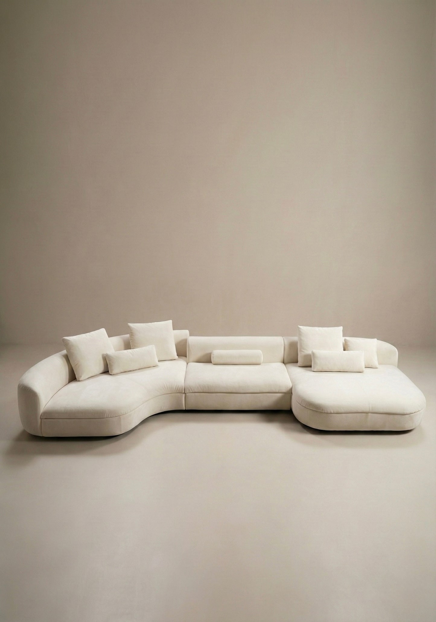 Large curved modular sofa in off white velvet upholstery with sculptural form and modular layout