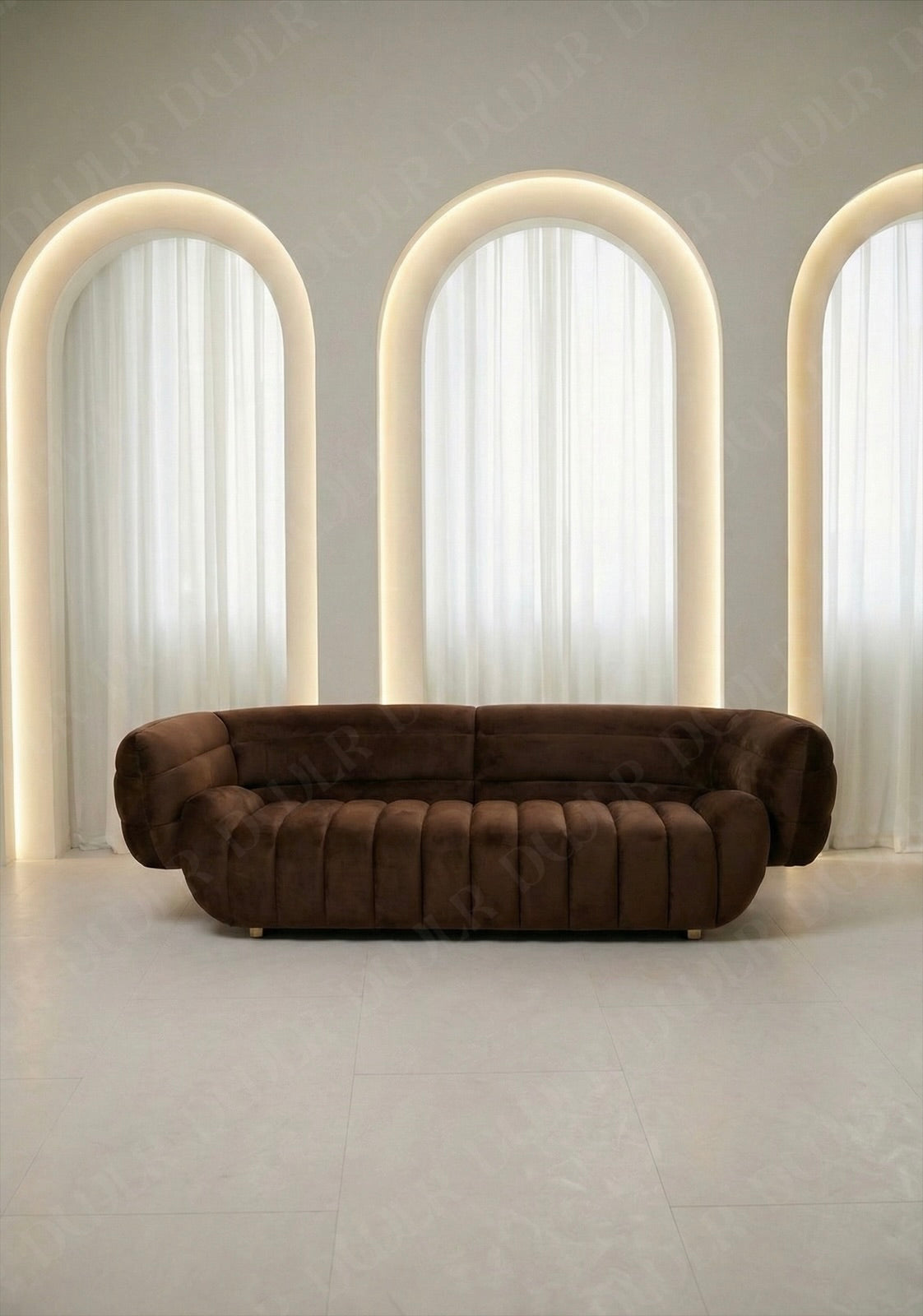Solara sofa in brown velvet upholstery with curved silhouette and channel tufted seat in modern living room.