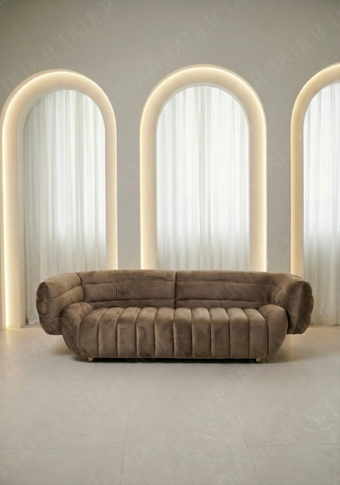 Solara sofa in taupe velvet upholstery with curved silhouette and channel tufted seat in modern living room.