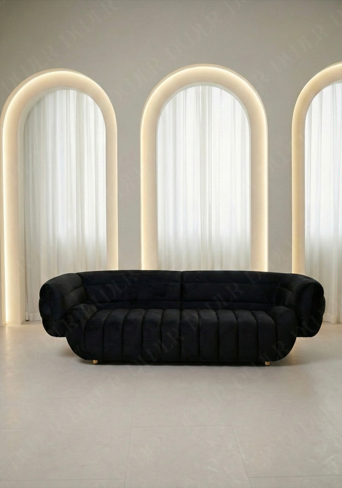 Solara sofa in black velvet upholstery with curved silhouette and channel tufted seat in modern living room.