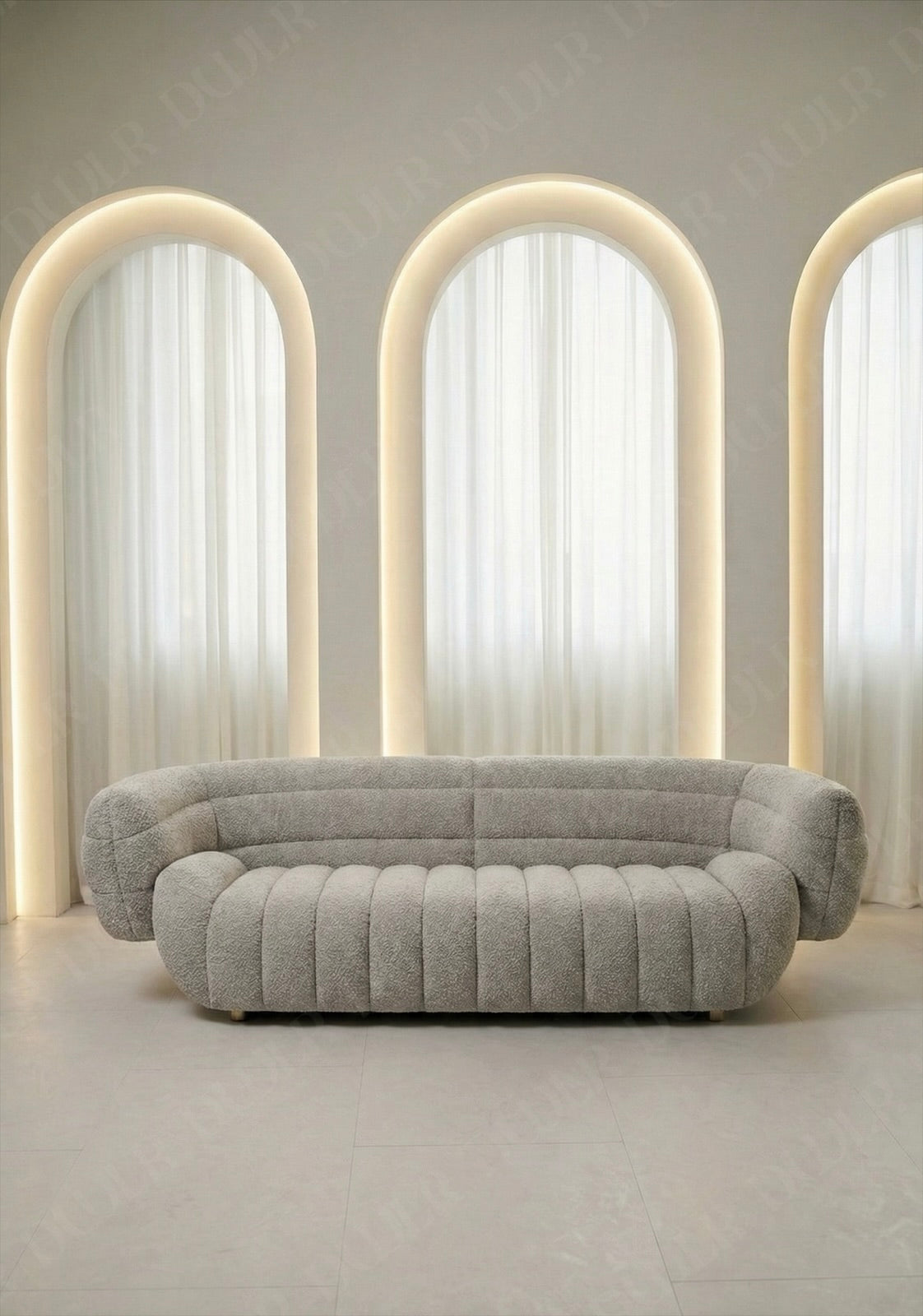 Solara sofa in light grey boucle upholstery with curved silhouette and channel tufted seat in modern living room.